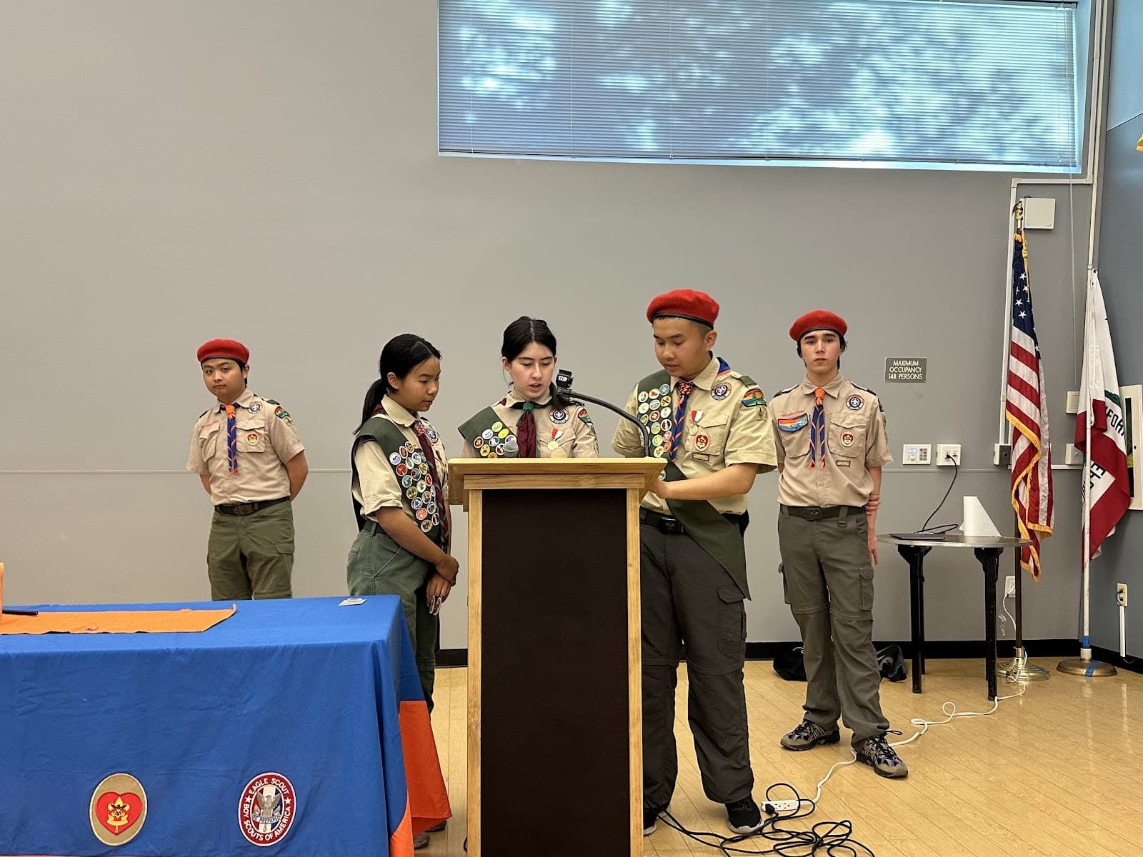 Scouts leading a court of honor ceremony at the front of the room